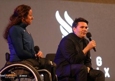 Photo of panelist Tatyana McFadden looking at Greg Nugent as he is holding the mic and facing the audience.